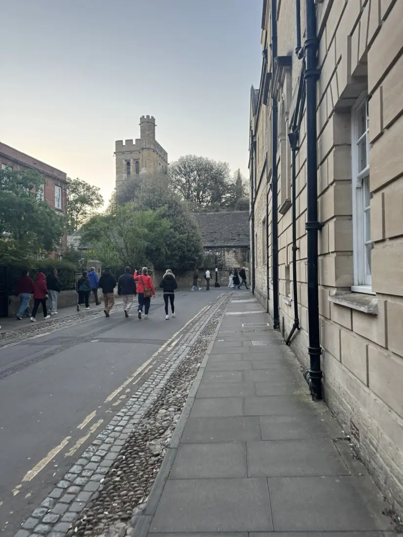 New College Lane under the Bridge of Sighs in pre-dawn light, heading toward Magdalen Tower, May Morning 2026