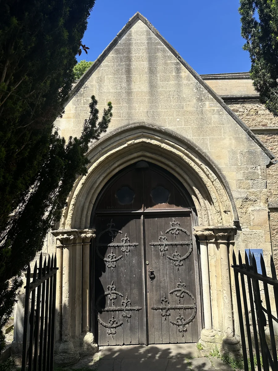 The medieval south doorway of St Giles' Church, framed by stone arch and weathered timber